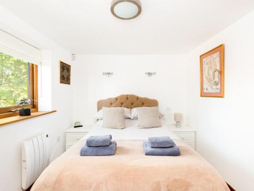 una camera da letto con un grande letto con asciugamani blu di Pass the Keys Rural Retreat in Rowington, Warwickshire a Warwick