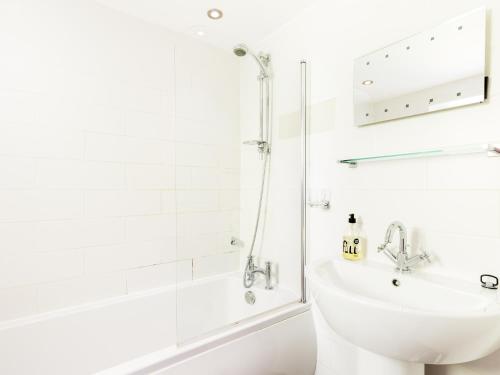 a white bathroom with a sink and a shower at Pass the Keys Rural Retreat in Rowington, Warwickshire in Warwick