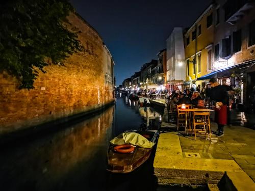 a canal at night with a boat in the water at Appartamento La Corte in Venice