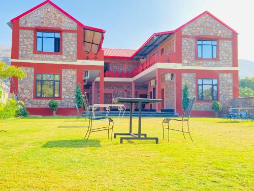 a table and chairs in front of a house at Pushkar Retreat Resort - The Nature and Mountain View Resort ,Pushkar in Pushkar