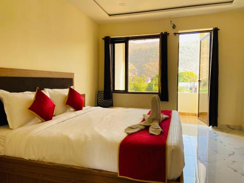 a bedroom with a large bed with red pillows at Pushkar Retreat Resort - The Nature and Mountain View Resort ,Pushkar in Pushkar