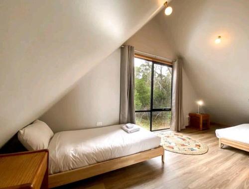 a bedroom with a bed and a large window at Periwinkle at Great Bay in Great Bay