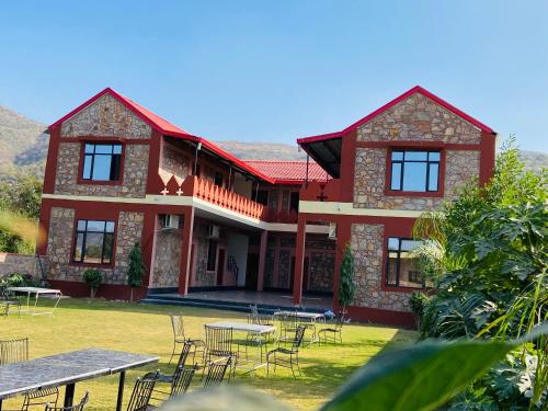 a house with tables and chairs in front of it at Pushkar Retreat Resort - The Nature and Mountain View Resort ,Pushkar in Pushkar