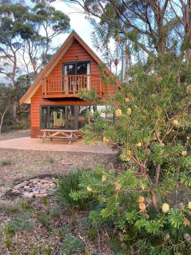a small wooden cabin with a porch and a deck at Periwinkle at Great Bay in Great Bay