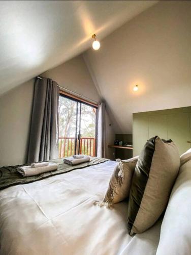 a large white bed in a room with a window at Periwinkle at Great Bay in Great Bay