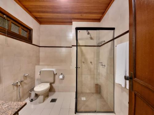 a bathroom with a toilet and a glass shower at APARTAMENTO GRAMADO HOTEL in Gramado