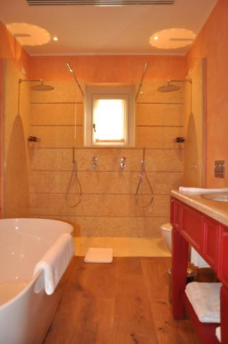 a bathroom with a tub and a toilet and a sink at L'Andana Tenuta La Badiola in Castiglione della Pescaia