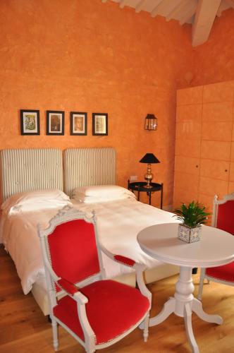 a bedroom with a bed and a table and chairs at L'Andana Tenuta La Badiola in Castiglione della Pescaia