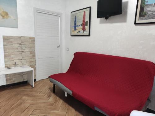 czerwona kanapa w pokoju z umywalką w obiekcie Cuscino e Cornetto w mieście Salerno