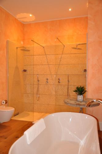 a bathroom with a tub and a shower and a sink at L'Andana Tenuta La Badiola in Castiglione della Pescaia