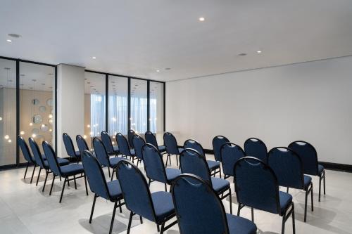 a row of chairs in a room with windows at Premier Splendid Inn Umhlanga in Durban