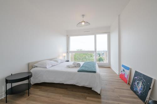 Un dormitorio blanco con una cama grande y una ventana en Stylish flat in Paris suburbs, en Saint-Michel-sur-Orge
