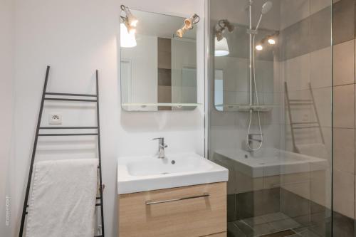 uma casa de banho branca com um lavatório e um chuveiro em Stylish flat in Paris suburbs em Saint-Michel-sur-Orge