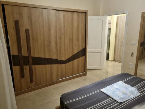 沙姆沙伊赫的住宿－Sharm el sheikh shahd，一间卧室设有一张床和木墙