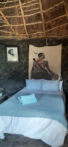 a bedroom with a bed in a stone wall at Casa Tumi Round Houses. 
