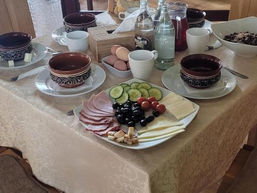 a table with a plate of food on a table at Pensiunea Flora in Băile Tuşnad