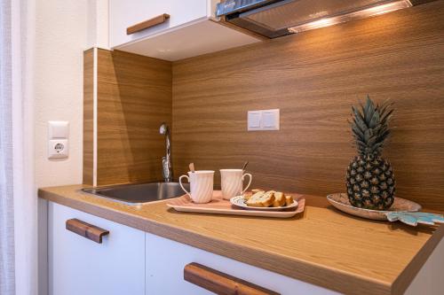 eine Küchentheke mit einem Teller mit Lebensmitteln und einer Ananas in der Unterkunft Senso Deluxe in Limenaria