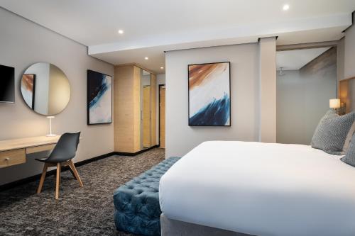 a hotel room with a bed and a desk at Premier Splendid Inn Umhlanga in Durban