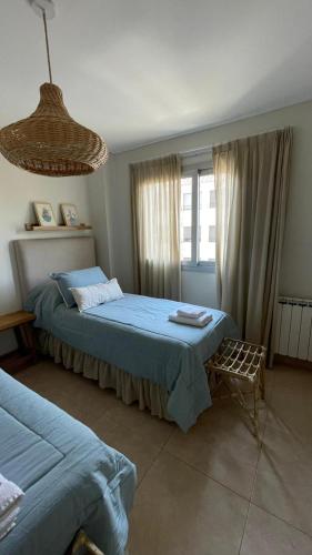 Un dormitorio con 2 camas y una silla. en Santiago Plaza Departamento Microcentro Premium en Salta