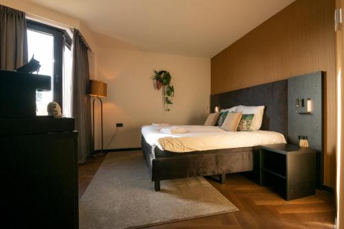 a bedroom with a bed with a large headboard at Hotel Lowietje Lisse - Keukenhof in Lisse