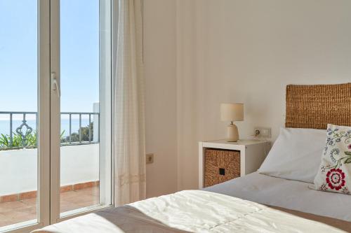 a bedroom with a bed and a large window at Los Altos 19 in La Herradura