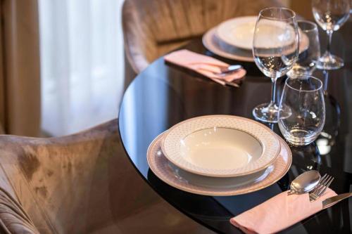 a black table with plates and wine glasses on it at Villa Nina - Apartments with pool near the sea in Rabac