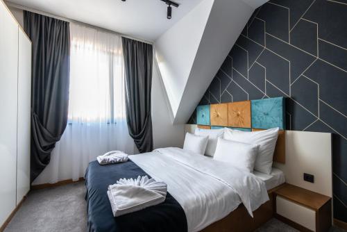 a bedroom with a large bed with a geometric headboard at Hotel Djina - Kopaonik in Kopaonik