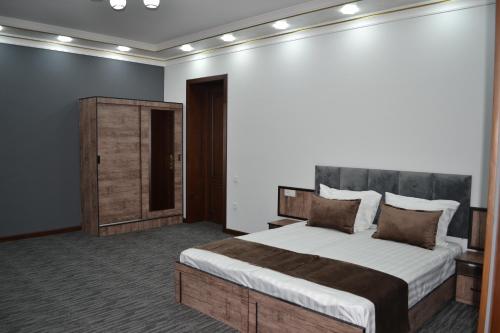 a bedroom with a large bed in a room at Art Angren Hotel in (( Sotsgorod ))