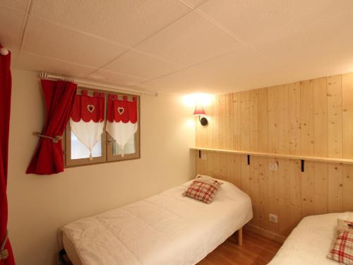 deux lits dans une chambre avec des rideaux rouges dans l'établissement Appartement T3 cosy avec WiFi, proche centre, Thermes & commodités, capacité 6 pers. - FR-1-608-214, à Le Mont-Dore