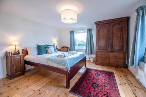 a bedroom with a bed and a dresser and a window at Solebay House in Woodbridge