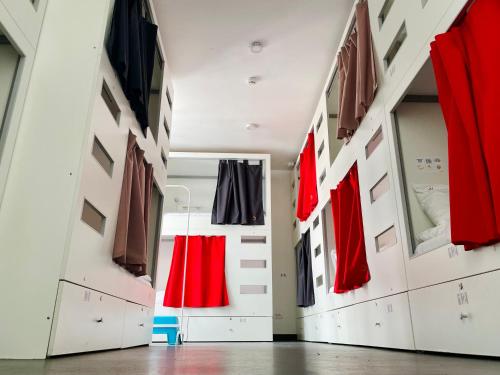a dressing room with red and black uniforms on display at Good People Design Hostel in Belgrade