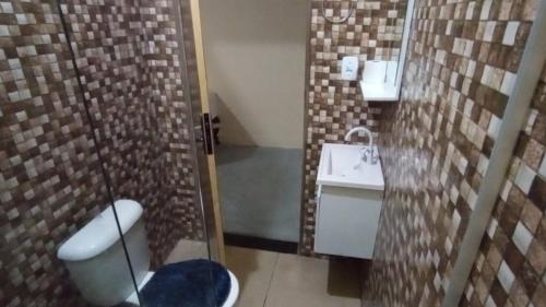 a small bathroom with a toilet and a sink at Residencial e Chalés Cristal in Palmeiras