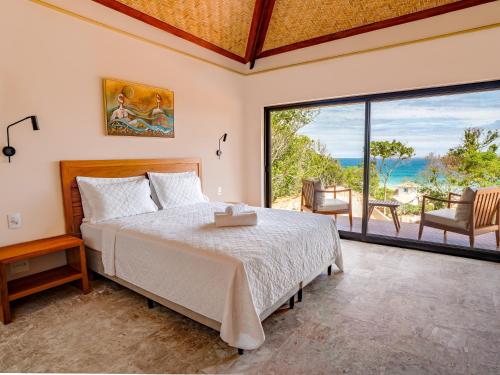 um quarto com uma cama e vista para o oceano em Buzios Espiritualidade Hotel em Búzios