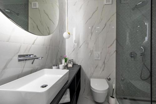 a bathroom with a sink and a toilet and a mirror at Villa Nina - Apartments with pool near the sea in Rabac