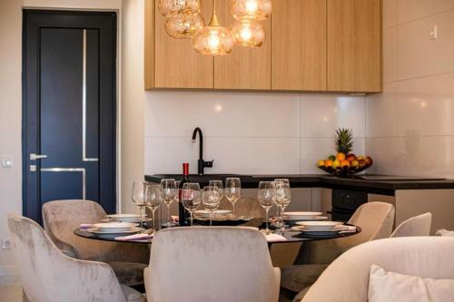 a table with wine glasses and chairs in a kitchen at Villa Nina - Apartments with pool near the sea in Rabac