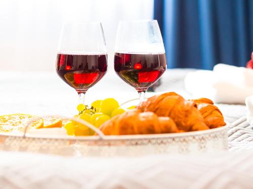 twee glazen rode wijn naast een bord eten bij Willa Moćkówka in Busko-Zdrój