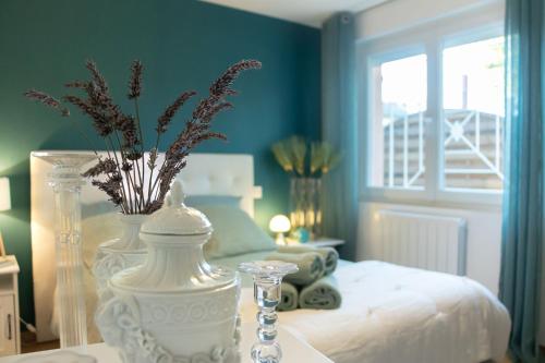 a bedroom with a bed with a vase with flowers in it at Gîte Marsau in Lacourt-Saint-Pierre