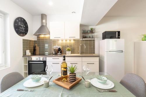 a kitchen with a table with a bottle of wine at Gîte Marsau in Lacourt-Saint-Pierre