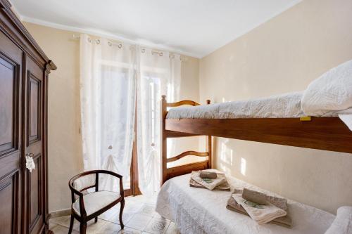 a bedroom with two bunk beds and a chair at Da Nonna Annetta in Nasino