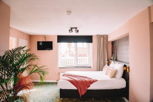 a bedroom with a bed and a window at Boutique Lodge Zandvoort in Zandvoort