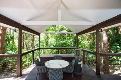 a screened porch with a table and chairs on it at Songbirds Rainforest Retreat in Mount Tamborine