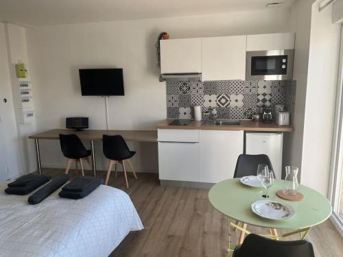 a room with a bed and a table and a kitchen at WAGNER’studio BALNÉO’terrasse au calme in Chasse-sur-Rhône