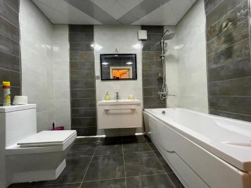 y baño con bañera, aseo y lavamanos. en Continental apartment, en Baku
