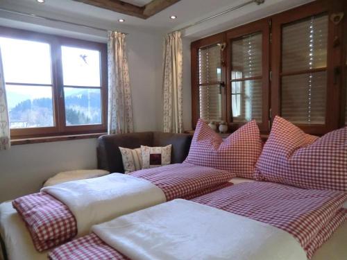 two beds sitting in a room with windows at Apartment-Chalet Mödlinghof in Hopfgarten im Brixental