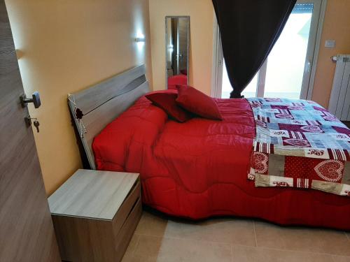 a bedroom with a bed with a red comforter at B&B A casa di Tetta in Telese