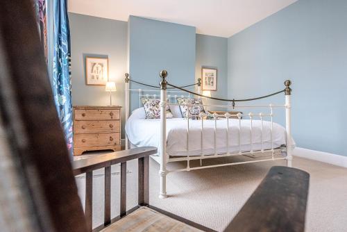 a bedroom with a white bed and a wooden dresser at 21 Park Lane, Aldeburgh in Aldeburgh