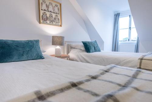 a bedroom with two beds and a window at 21 Park Lane, Aldeburgh in Aldeburgh