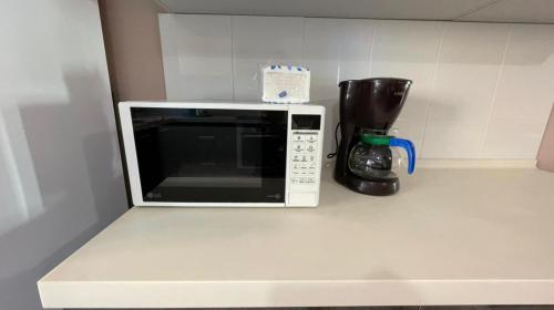 a microwave sitting on a counter with a coffee maker at На Тархана in Astana