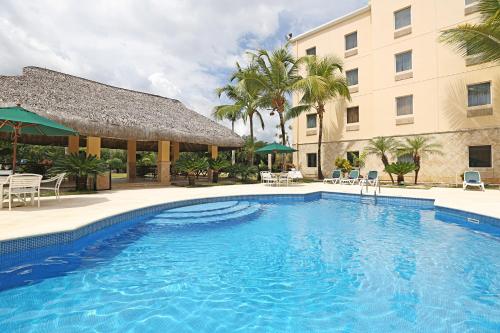 a large swimming pool in front of a hotel at Quality Hotel Real Aeropuerto Santo Domingo in Boca Chica