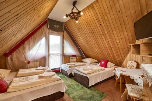 ザコパネにあるZakopiankaのベッド3台と窓が備わる客室です。